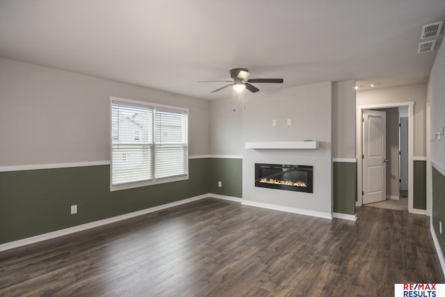 unfurnished living room with ceiling fan and dark hardwood / wood-style flooring