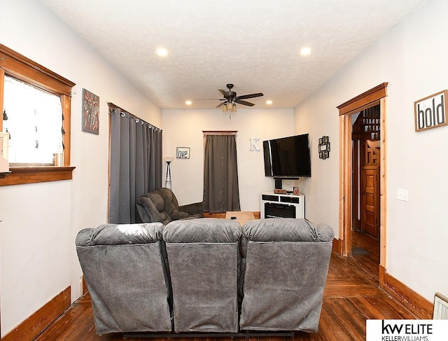 living room with ceiling fan and a textured ceiling