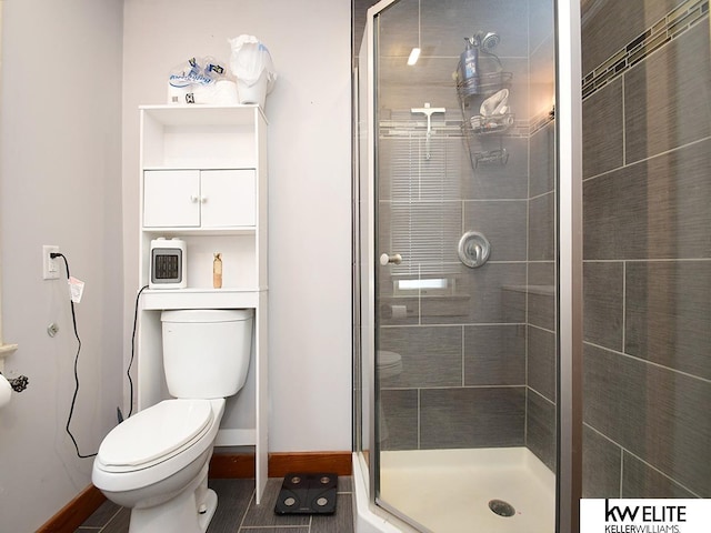 bathroom with toilet and a shower with shower door