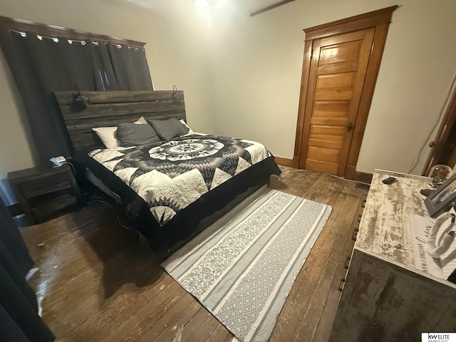 bedroom with dark wood-type flooring