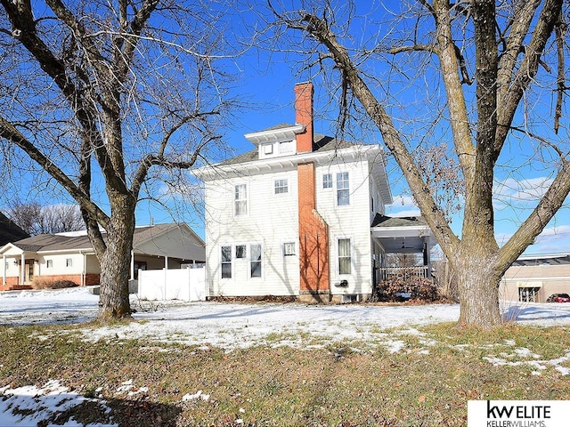 view of snow covered back of property