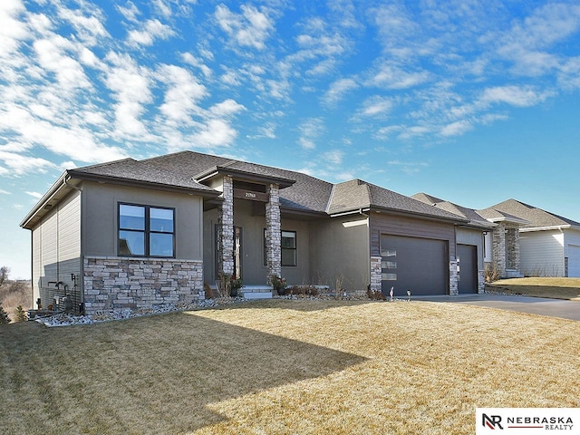 prairie-style home featuring a garage and a front lawn