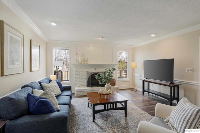 living room featuring hardwood / wood-style flooring, crown molding, a brick fireplace, and plenty of natural light