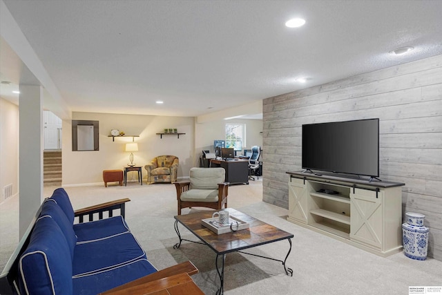 carpeted living room featuring wooden walls and a textured ceiling