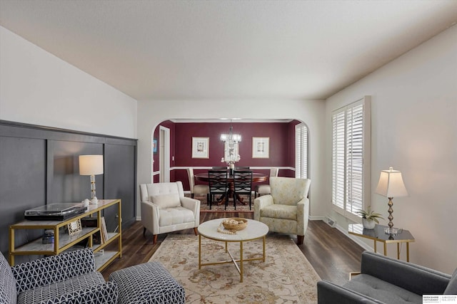 living room with a notable chandelier and dark hardwood / wood-style floors