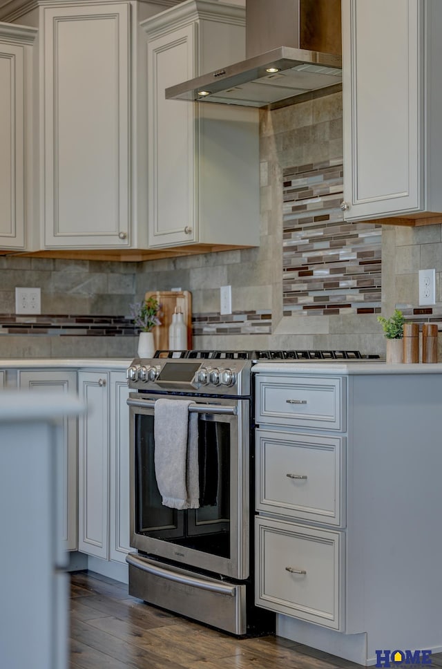 kitchen featuring tasteful backsplash, wall chimney exhaust hood, white cabinets, and light countertops