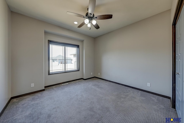 unfurnished room featuring ceiling fan, carpet, visible vents, and baseboards