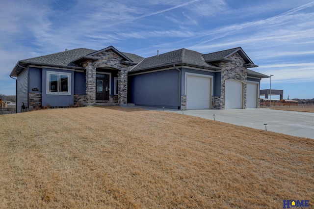 view of front of property with a garage, stone siding, a front lawn, and concrete driveway