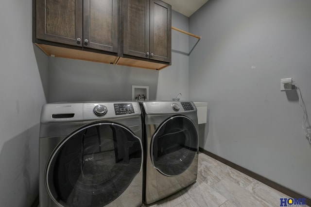 clothes washing area with independent washer and dryer, cabinet space, and baseboards