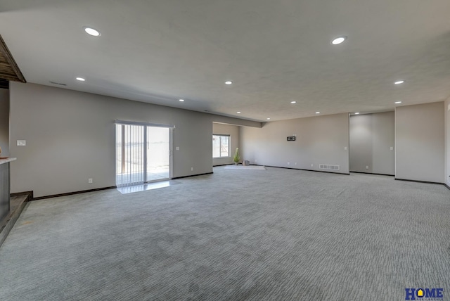 unfurnished living room featuring baseboards, recessed lighting, visible vents, and light colored carpet