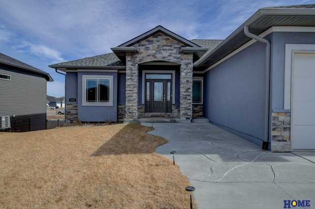 exterior space featuring stone siding, roof with shingles, and stucco siding