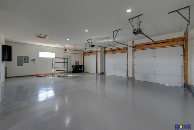 garage with recessed lighting, electric panel, and a garage door opener