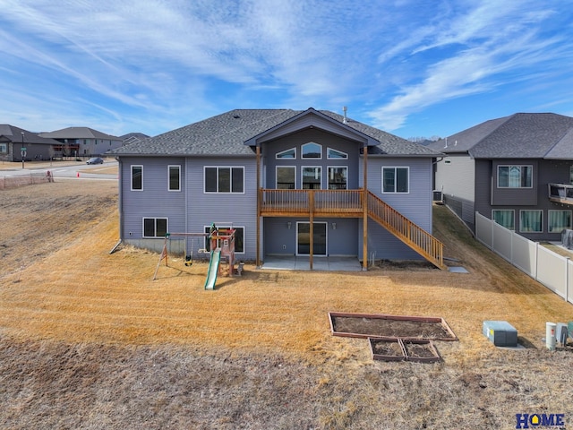 back of house featuring stairs, fence, a patio, and a yard