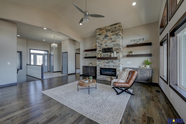 living room with baseboards, visible vents, dark wood finished floors, a fireplace, and high vaulted ceiling