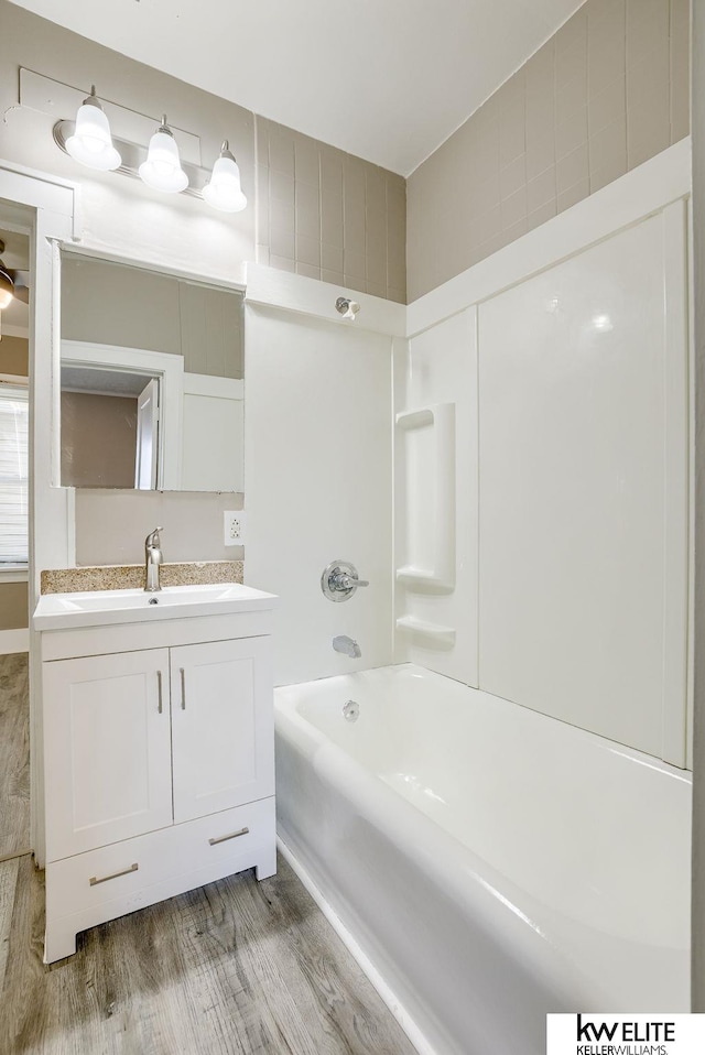 bathroom with hardwood / wood-style flooring, vanity, and  shower combination