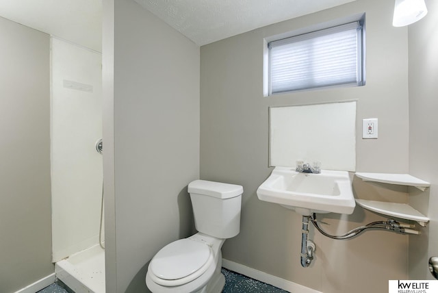 bathroom with sink, a textured ceiling, a shower, and toilet