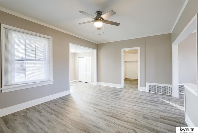 spare room featuring ornamental molding, ceiling fan, and light hardwood / wood-style flooring