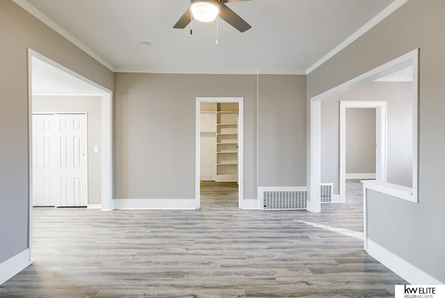 empty room featuring crown molding, ceiling fan, and light wood-type flooring