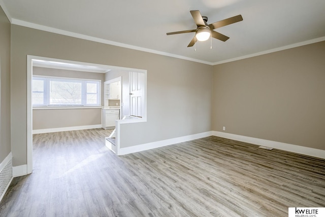 spare room with crown molding, ceiling fan, and light hardwood / wood-style floors