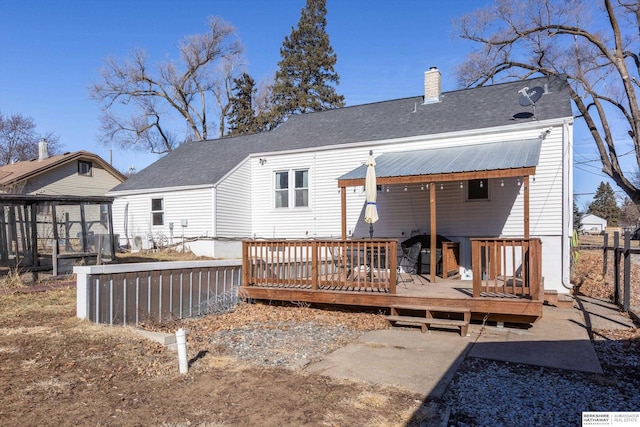 rear view of property featuring a wooden deck and a sunroom