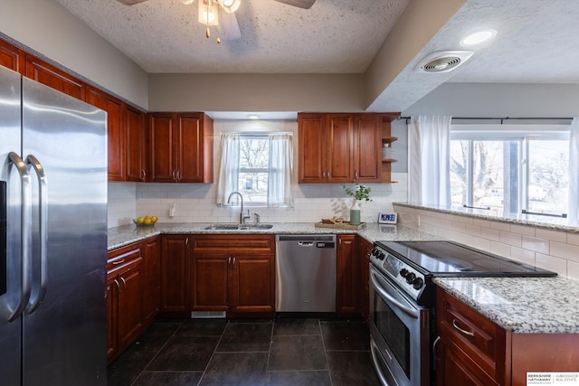 kitchen featuring sink, backsplash, light stone countertops, and appliances with stainless steel finishes