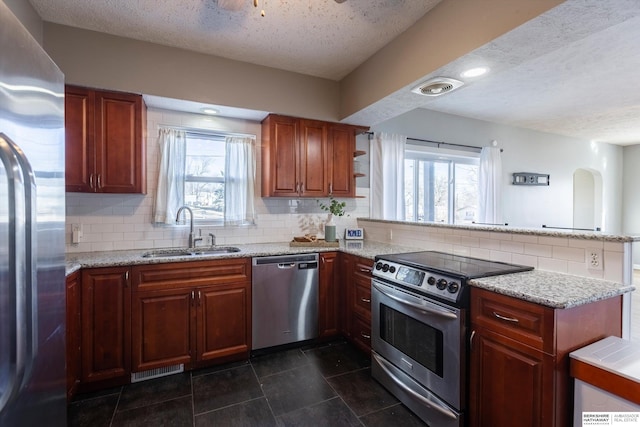 kitchen with stainless steel appliances, plenty of natural light, sink, and kitchen peninsula