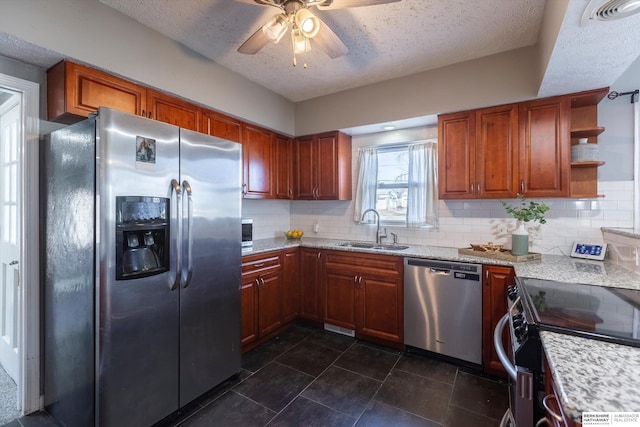 kitchen featuring tasteful backsplash, appliances with stainless steel finishes, sink, and light stone counters