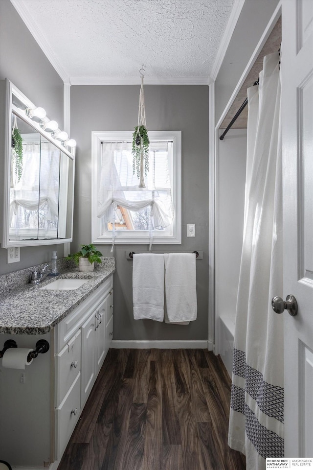 bathroom with vanity, hardwood / wood-style flooring, ornamental molding, and a textured ceiling