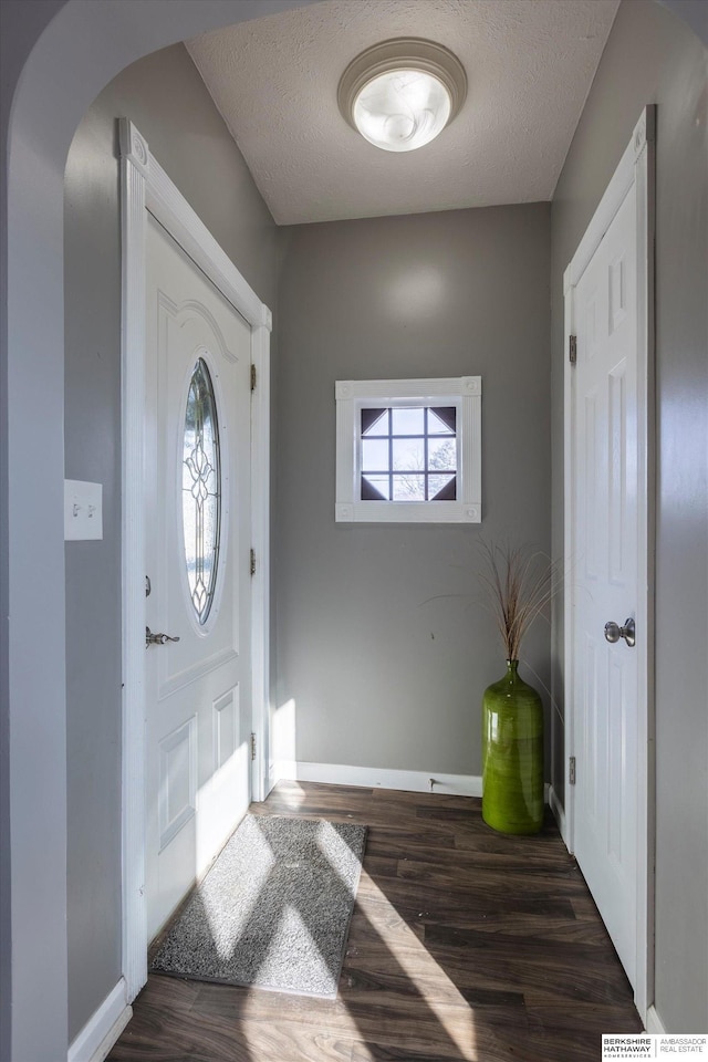 entryway featuring a textured ceiling and dark hardwood / wood-style flooring