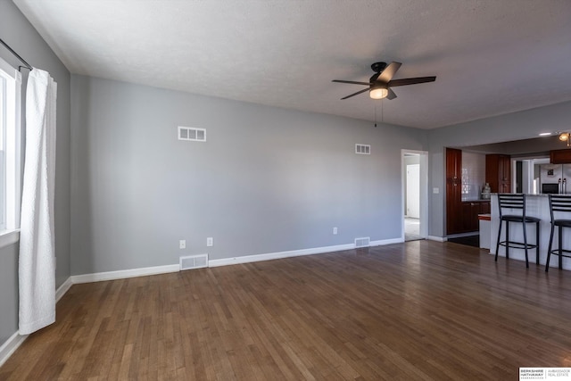 unfurnished living room with ceiling fan and dark hardwood / wood-style flooring