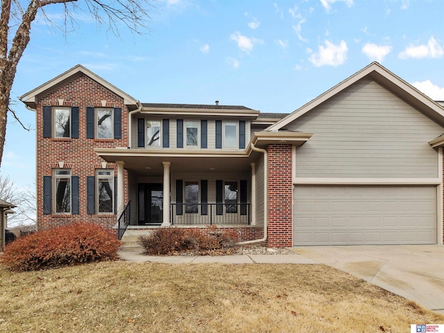 view of front of property featuring a garage, covered porch, and a front lawn