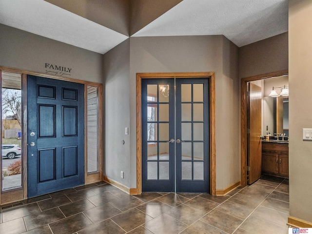 foyer with dark tile patterned floors and french doors