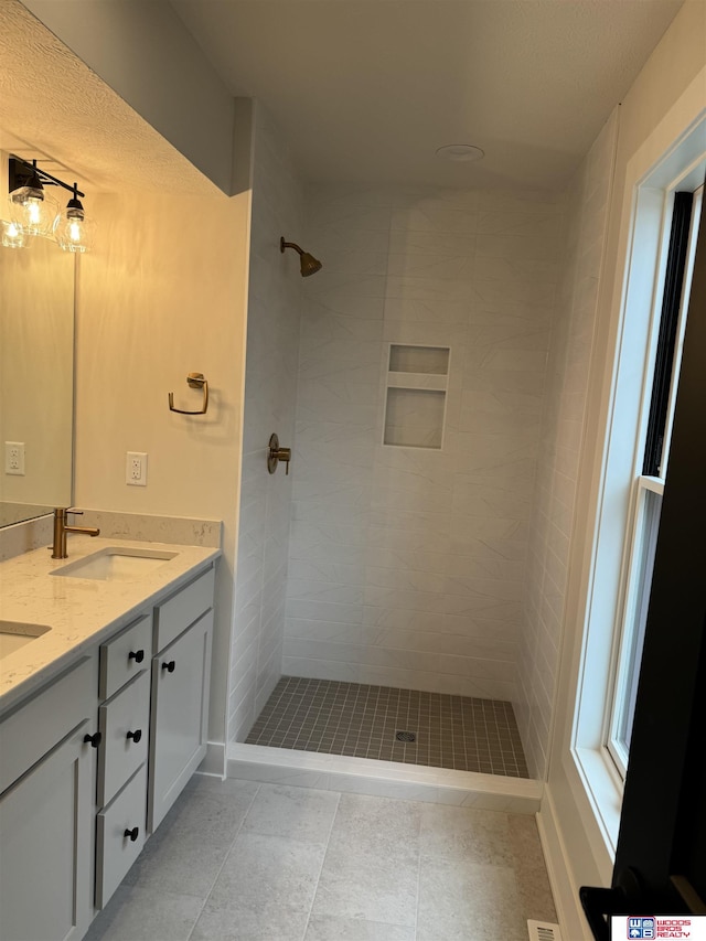 bathroom with vanity and a tile shower