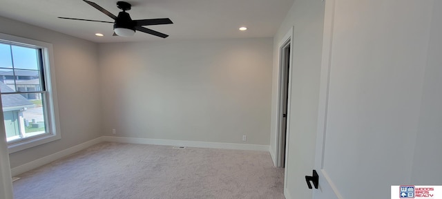 carpeted spare room with plenty of natural light and ceiling fan