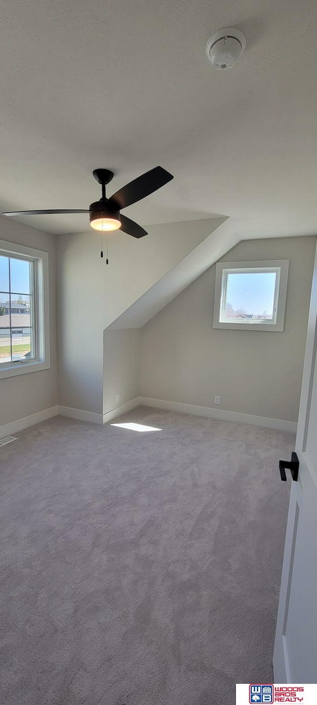 bonus room featuring lofted ceiling, light colored carpet, and ceiling fan