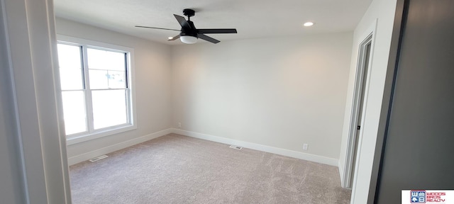 carpeted spare room featuring a wealth of natural light and ceiling fan