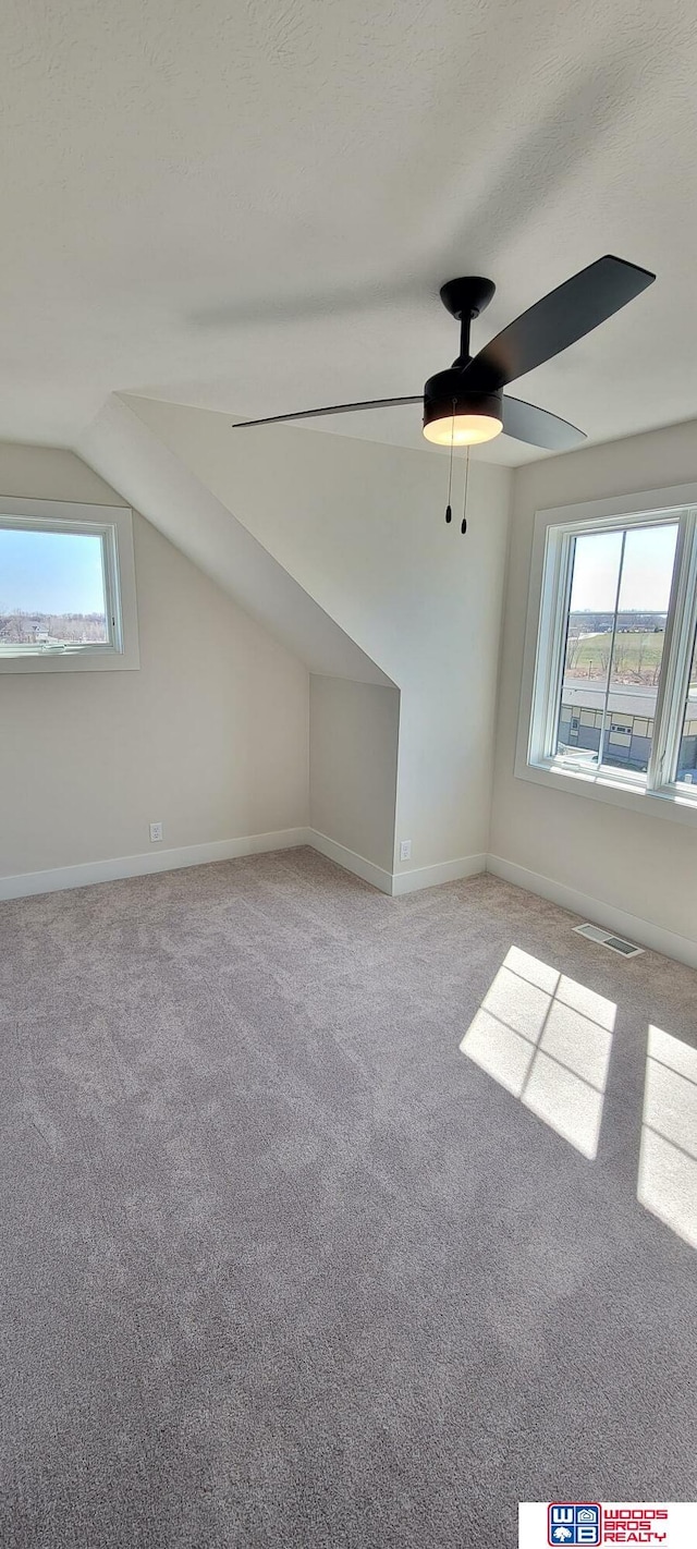 bonus room featuring ceiling fan, light colored carpet, and vaulted ceiling