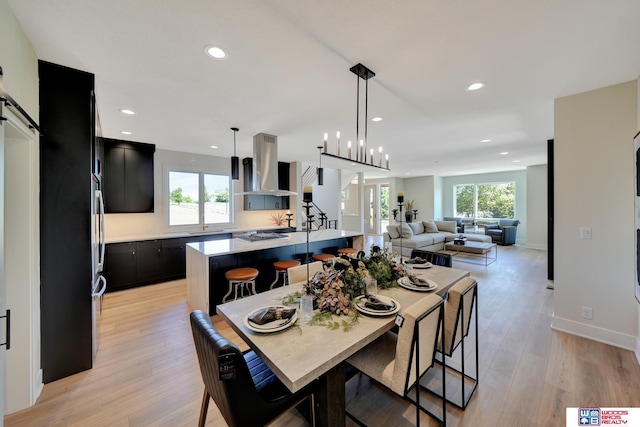 dining space featuring a barn door, a wealth of natural light, and light hardwood / wood-style floors