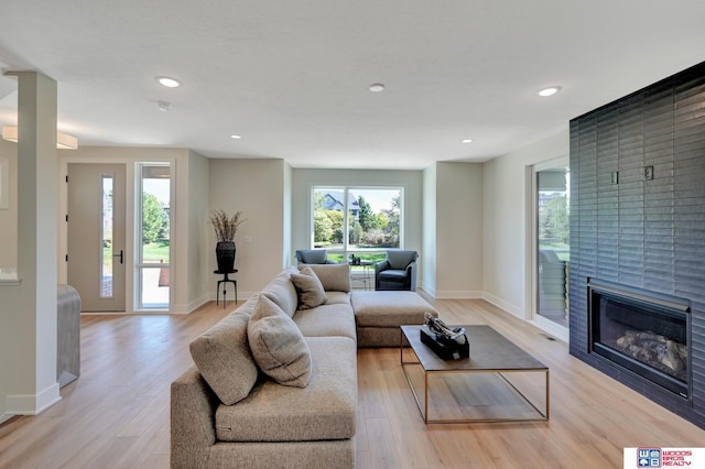 living room featuring a large fireplace and light wood-type flooring