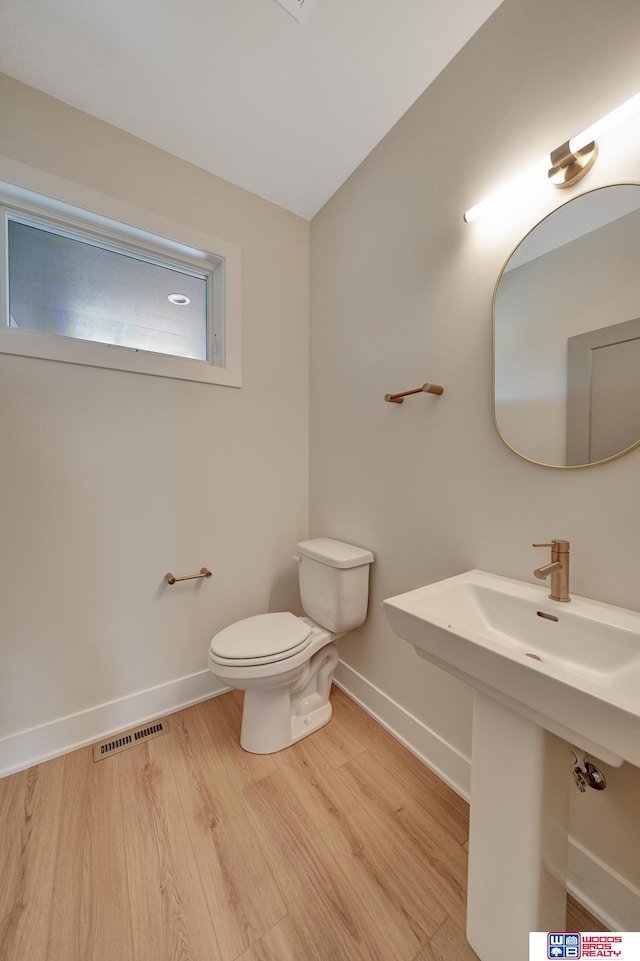 bathroom with hardwood / wood-style flooring and toilet