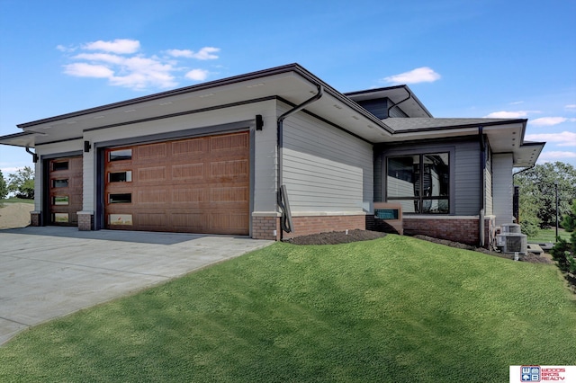 view of front facade featuring central AC unit, a garage, and a front lawn