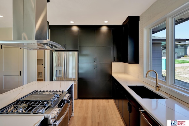 kitchen featuring sink, stainless steel appliances, light hardwood / wood-style floors, and island exhaust hood