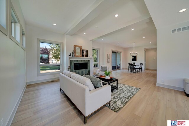 living area with light wood-type flooring, a fireplace, baseboards, and recessed lighting