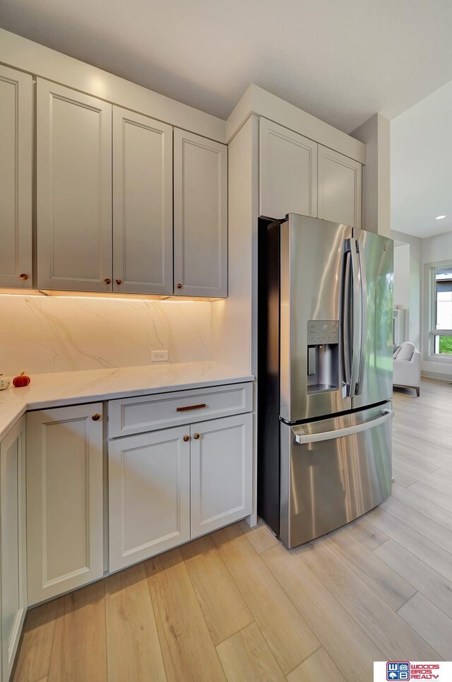 kitchen featuring light wood-style flooring, light countertops, and stainless steel fridge with ice dispenser