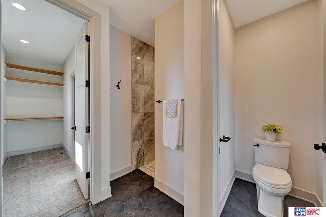 full bathroom with toilet, recessed lighting, baseboards, a spacious closet, and walk in shower