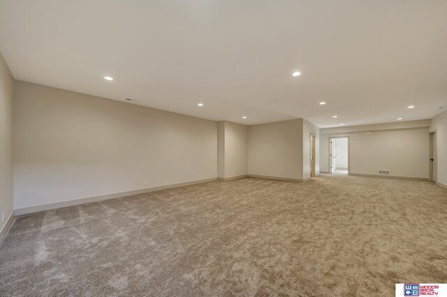 spare room featuring recessed lighting, baseboards, and light colored carpet