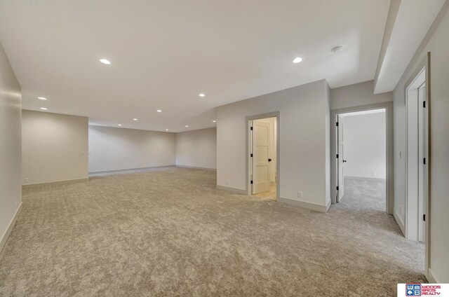 basement featuring recessed lighting, light colored carpet, and baseboards