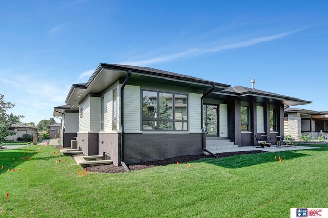 view of front of home with brick siding and a front lawn