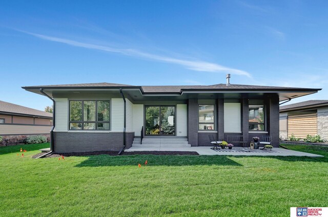 rear view of property with a yard and brick siding