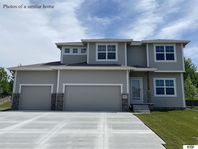 prairie-style home with a garage and a front lawn